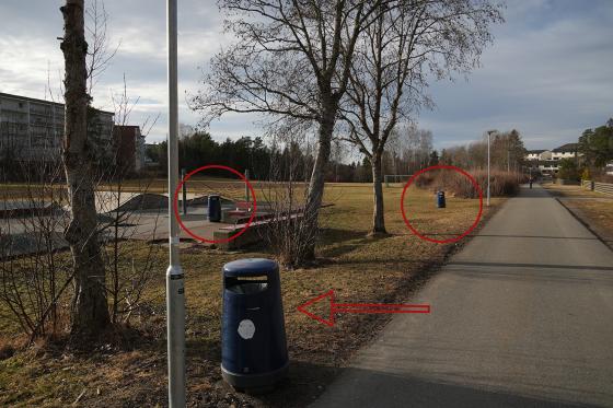 Tre søppelbøtter ligger svært nærme hverandre ved en lekeplass. Sirkler og piler viser hvor søppelbøttene er.