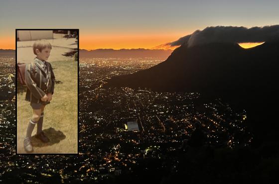 Bilde av Cape Town om kvelden med et bilde av en liten gutt i skoleuniform over.