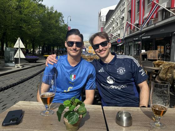 To gutter med fotballdrakt smiler til kamera