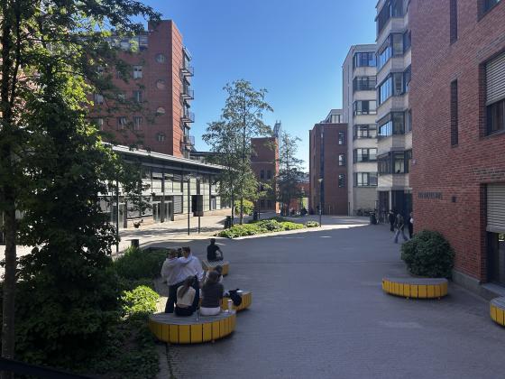 OsloMet campus og elever som sitter på en benk