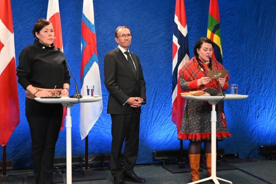 pressekonferanse med tre personer stående foran ulike flagg. Personene er Vivian Motzfeldt, Espen Barth Eide og Silje Karine Muotka. Dette er politiske ledere i Grønland, Norge og Sametinget. På bildet taler Muotka, presidenten på Sametinget. 