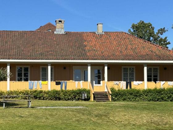 Et gult hus hvor de har hengt klær på gelenderet