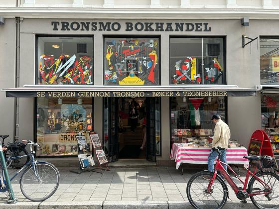 Bilde av fasaden til Tronsmo bokhandel, en mann kikker på bøkene i vinduet