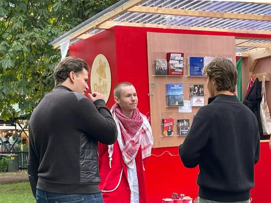 Rødtverver snakker med to unge menn