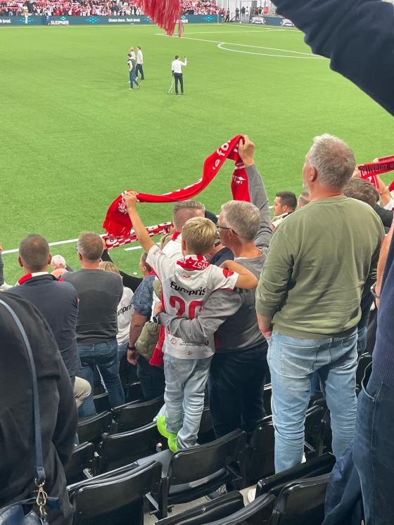 Far og sønn som holder rundt hverandre på fotballkamp