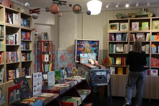 Dame står i en bokhandel og ser på barnebøker.