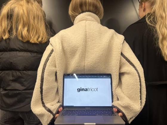 Tre jenter som holder en PC med Gina Tricot