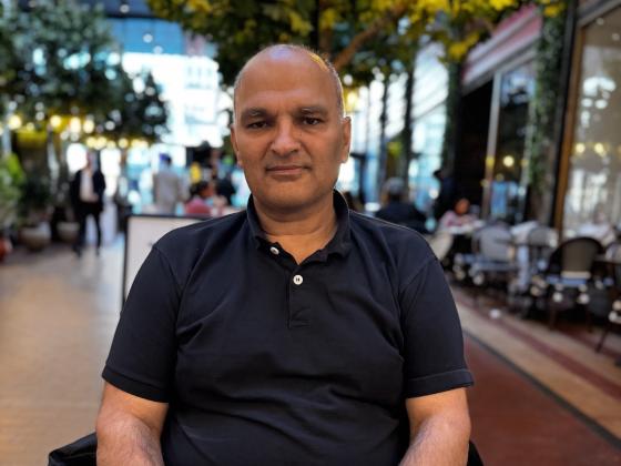 Rashid Nawas som sitter ved et bord, på folketeatret.