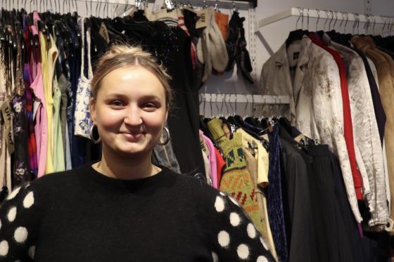 Sunniva som står i bruktbutikken UFF, der hun jobber.