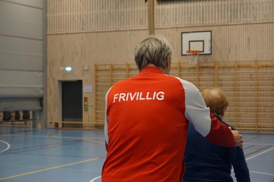 Nærbilde av frivillig som hjelper en med demens