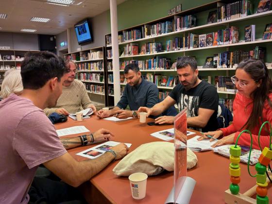 Mennesker rundt et bord på et bibliotek
