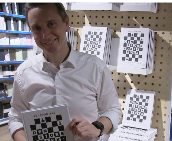 Torstein Bae med boka "Den store sjakkboka"
