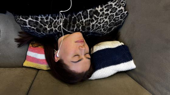 Jente sover med musikk i &oslash;rene.