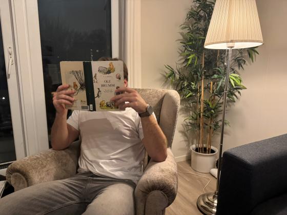 Mann som leser Ole Brumm.