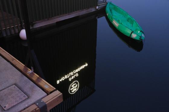 Logoen til Oslo Badstuforening reflekteres i vannet