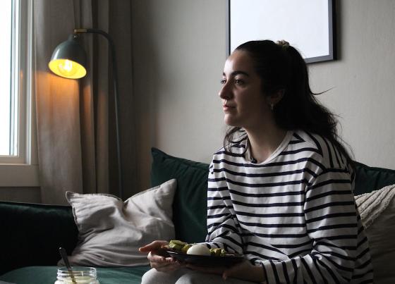 Aurora som sitter i sofaen og spiser frokost 