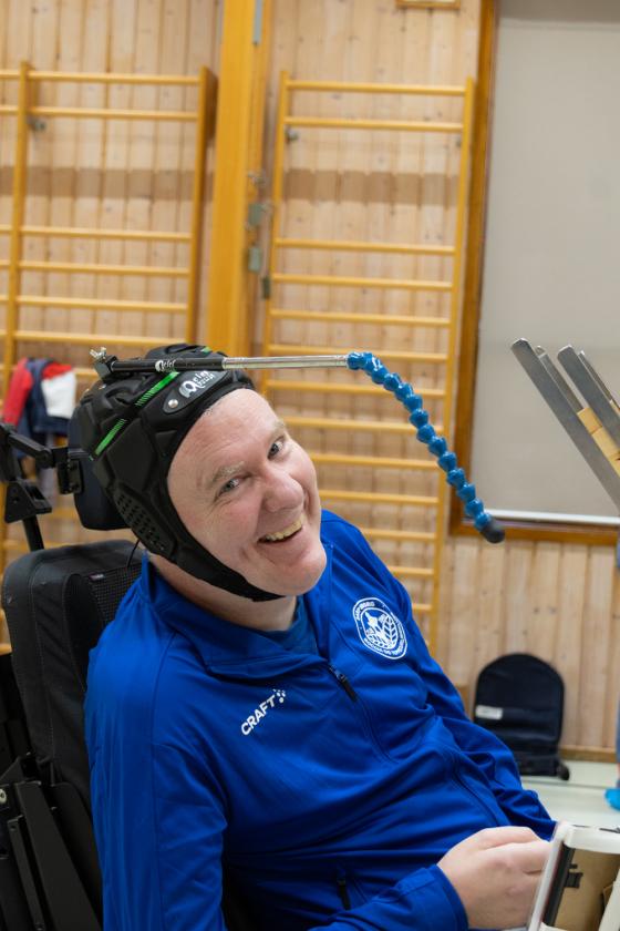 Christer smiler til kameraet med en hjelm med en antenne p&aring; hodet