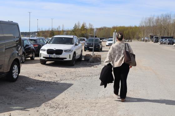 jente med ryggen til som g&aring;r mot bilen sin 