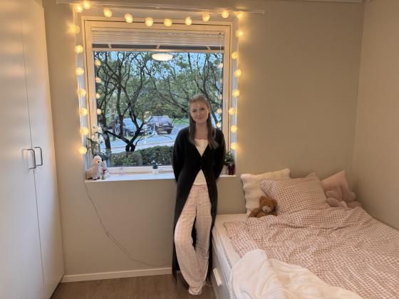 Studenten Caroline som st&aring;r i studentboligen sin.