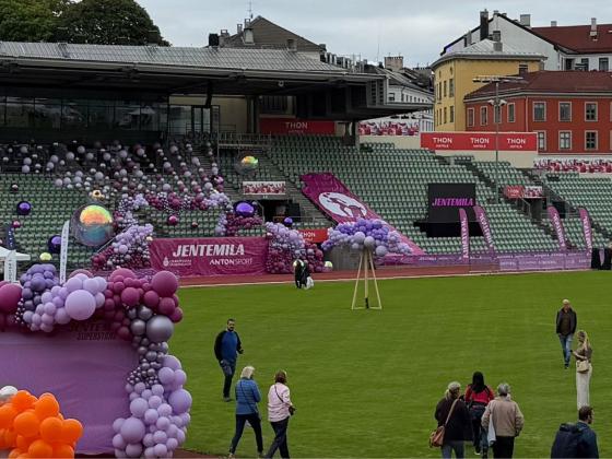 Oversiktsbilde av Bislett stadion pyntet med lilla og rosa ballonger, stands og Jentemila-bannere. 