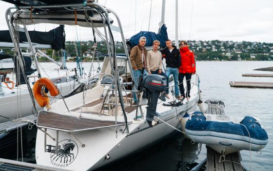 Fire gutter st&aring;r p&aring; siden av seilb&aring;ten "sleipner"