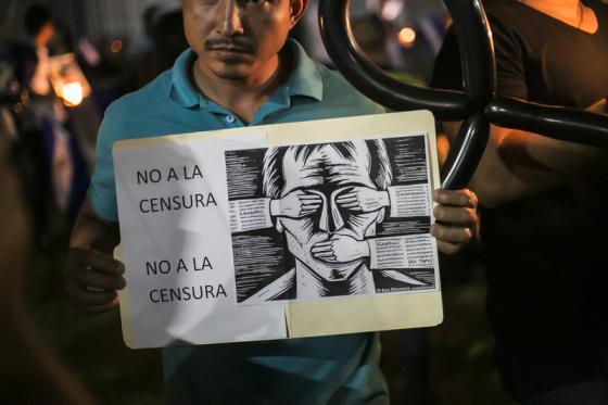 En demonstrant i Nicaragua holder opp et skilt hvor det står "Nei til sensur"