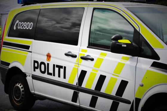 En politibil fra siden med skriften "politi".