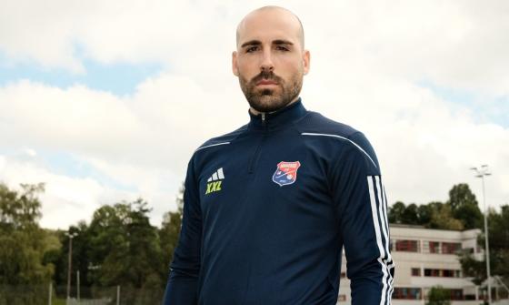 Hovedtrener i Haugerud IF, Alvaro Torres Arjona, poserer i treningsoverdel på en fotballbane. 