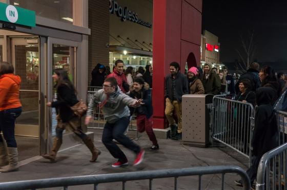 mann løper inn i en butikk på black friday fordi det er store salg. 