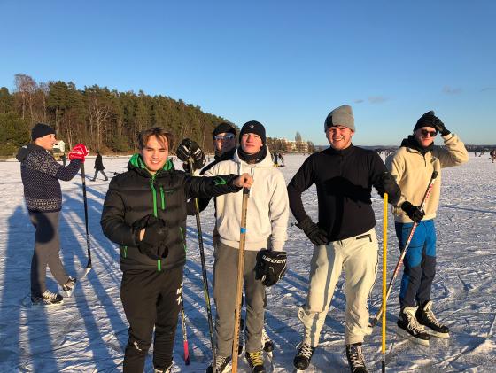 Gruppebilde av folk som spiller ishockey på fjordisen