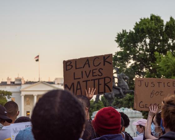 Folk i protest som holder plakater med teksten "Black Lives Matter"