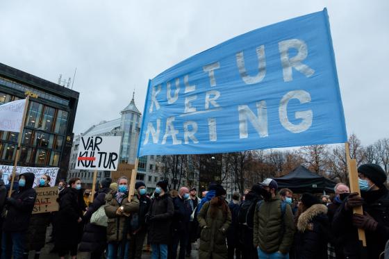 Demonstranter fra kulturlivet holder plakater og bannere foran Stortinget.