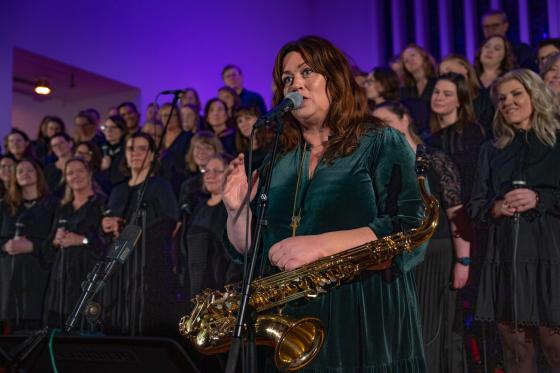 Saxofonist Frøydis Grorud står foran koret Gospel explosion