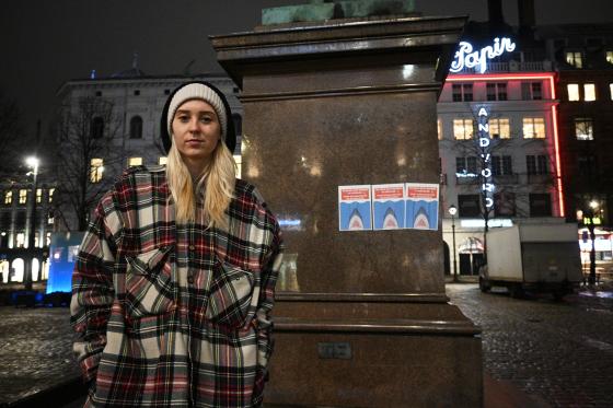 Dyveke Irene Duseth Lundsæter foran statue med plakater, på Stortorvet.