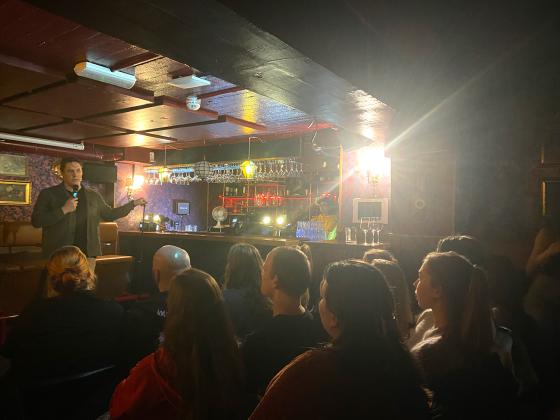 Komiker Espen Abrahamsen som står på scenen og gjør stand-up. 