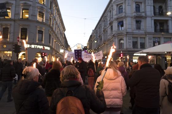 En mengde folk som går i fakkeltog foran Stortinget