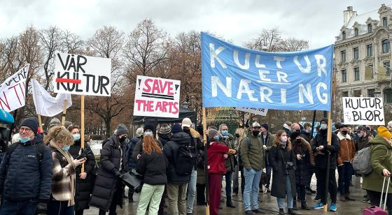 Mennesker som står med bannere på Eidsvolds plass