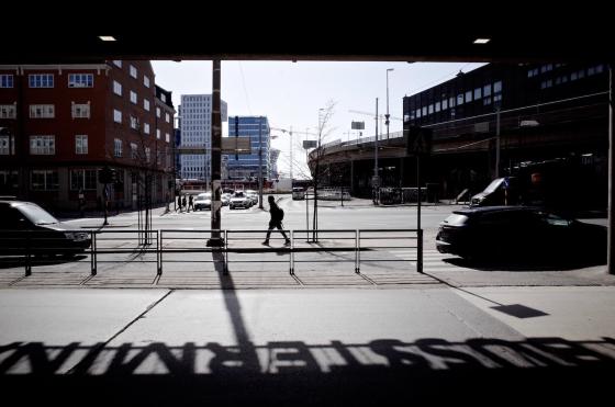 En mørkt kledd mann går langs en vei utenfor Bussterminalen i Oslo. 