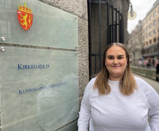 Kvinne står foran Kunnskapsdepartementet