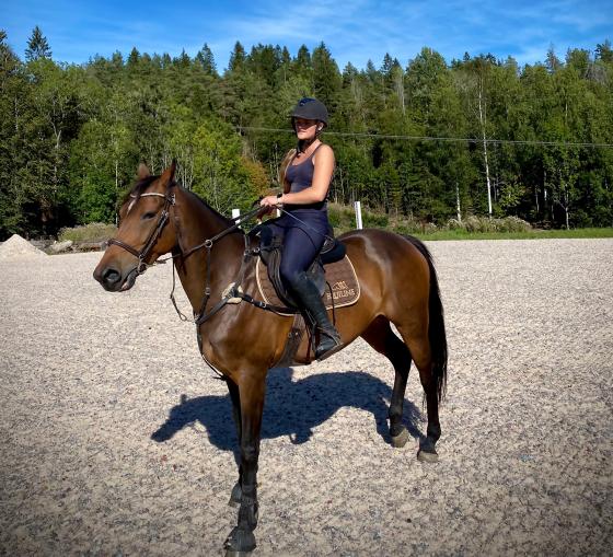 På bildet ser man Ida Bærøe Bjørn, som sitter på en stor brun hest, på sprangridebanen i Røyken.