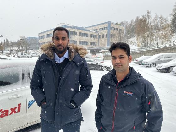 Ismail Shariff og Mohammad Saad står i snøværet utenfor et bilverksted på Stovner i Oslo. 