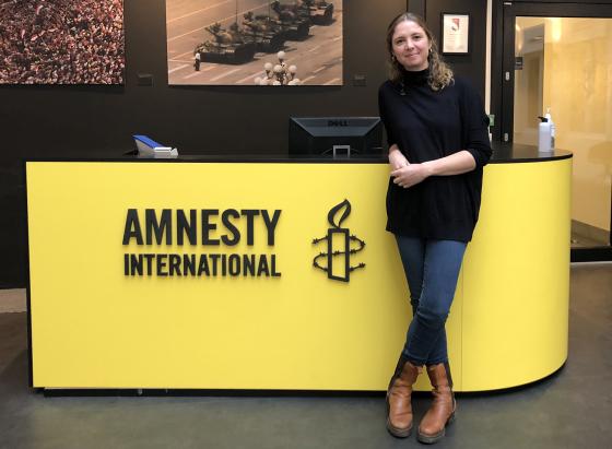 Ingrid Westgaard Stolpestad stående foran inngangen til kontoret hos Amnesty.