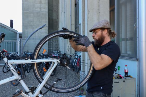 Ivar Örn Sverrisson, en islending med skjegg, fikser på en sykkel.