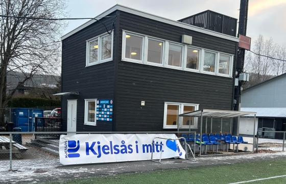 Kjelsåsbua og et banner der det står "Kjelsås i mitt hjerte" på Grefsen stadion