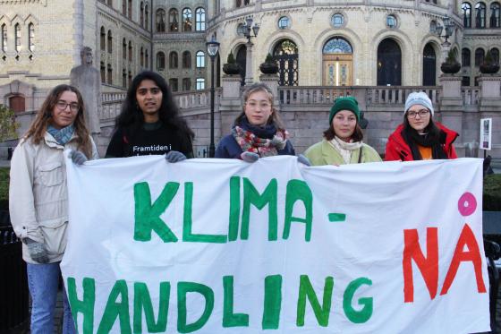 Unge som holder en plakat foran Stortinget