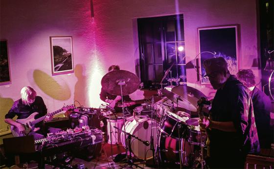 Et band på fire stykker spiller musikk på møllefossen kafe. To av de er gitarister. Hvor to spiller på trommer, men også bruker hva som ligner på stump instrumenter. 