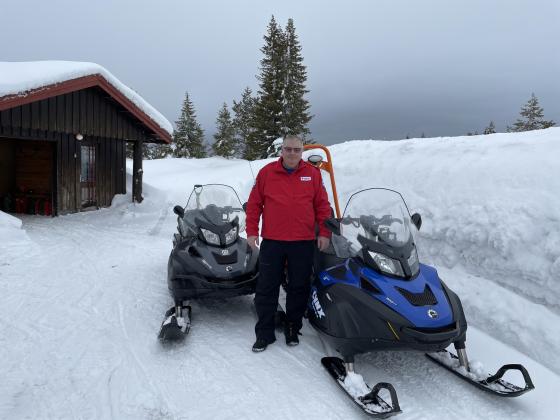 Mann foran to snøscootere