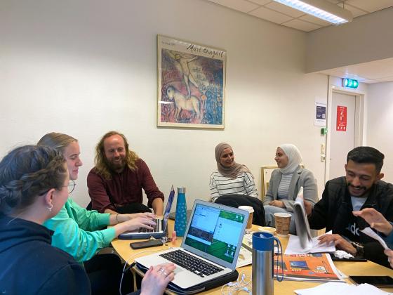 gruppe diskuterer rundt bord