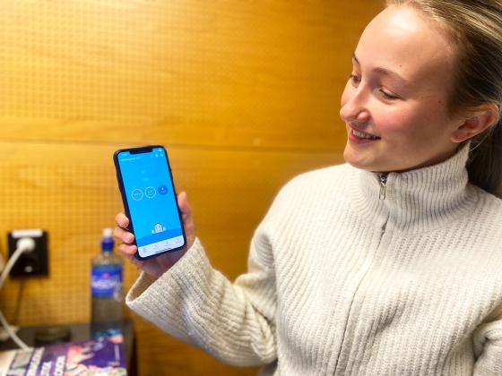 Student viser frem telefon med strømapp