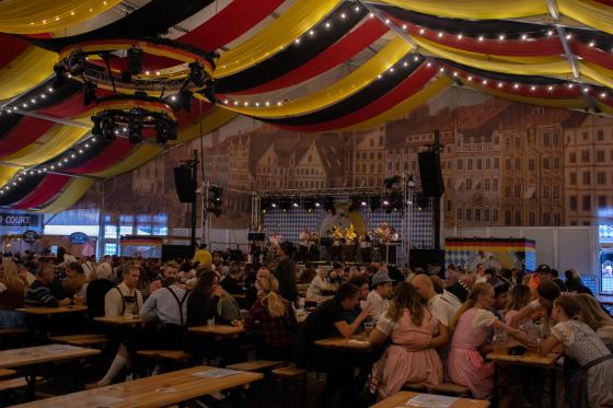 Inn i teltet til oktoberfest. Vi ser flere personer som har det gøy og hører på de tyske sangene i bakgrunnen.